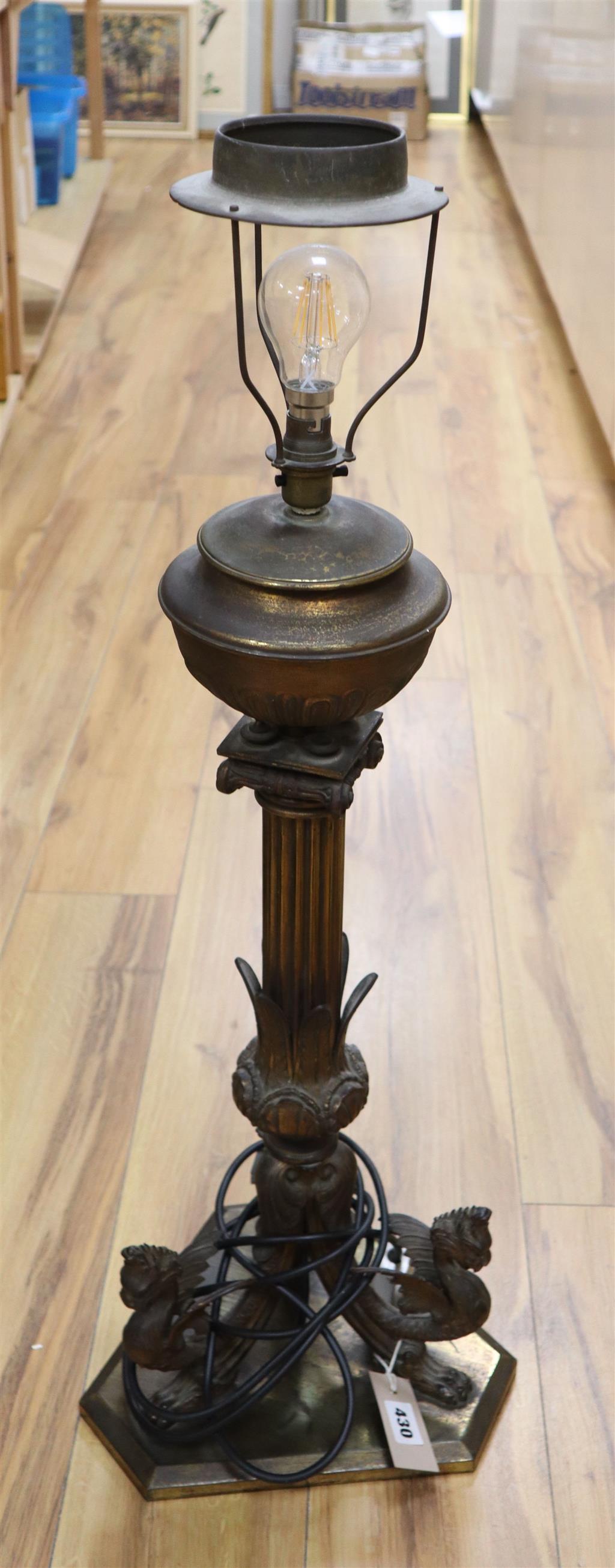 A 19th century gilt bronze and brass oil lamp on tri-form dragon supports (converted for electricity)